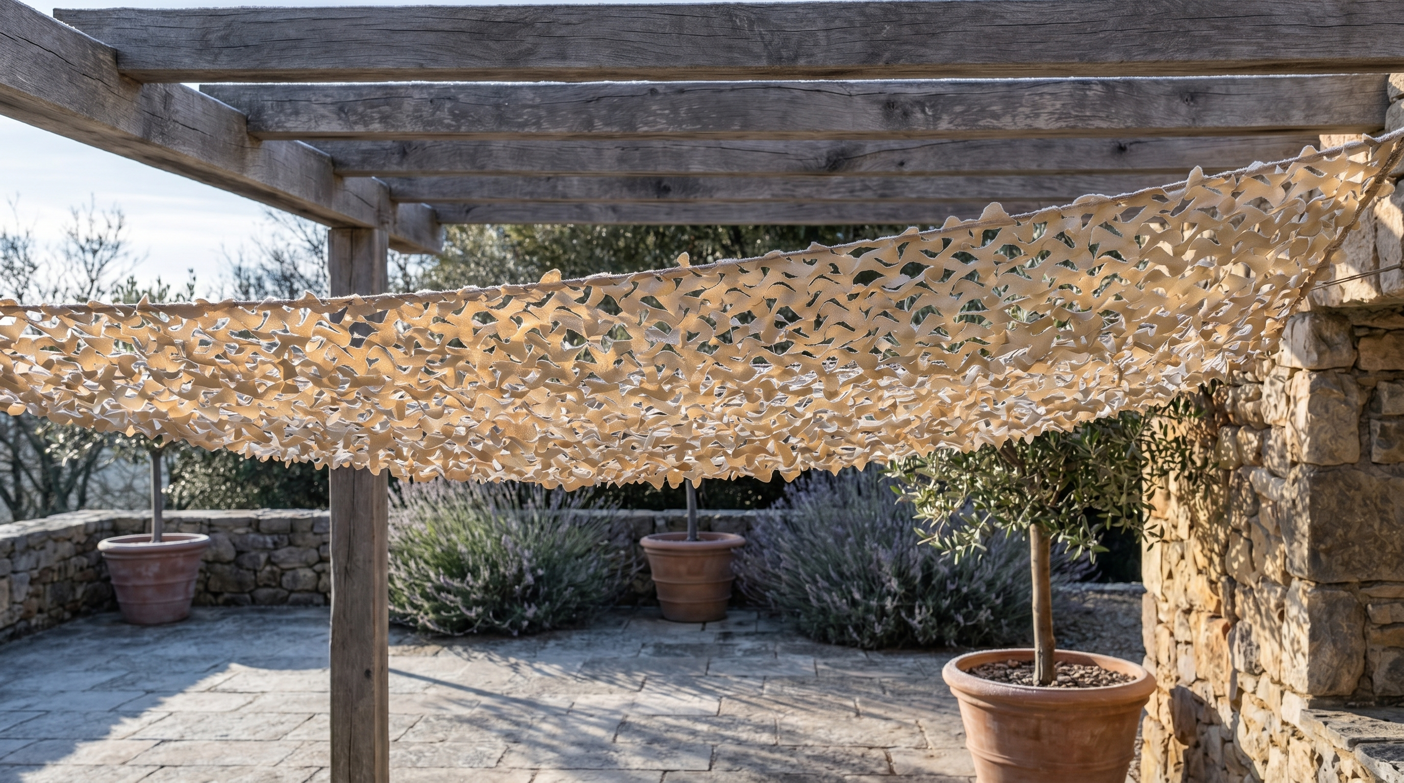 Un filet de camouflage en hiver Camofil tendu sur une pergola en bois pour tester sa résistance.