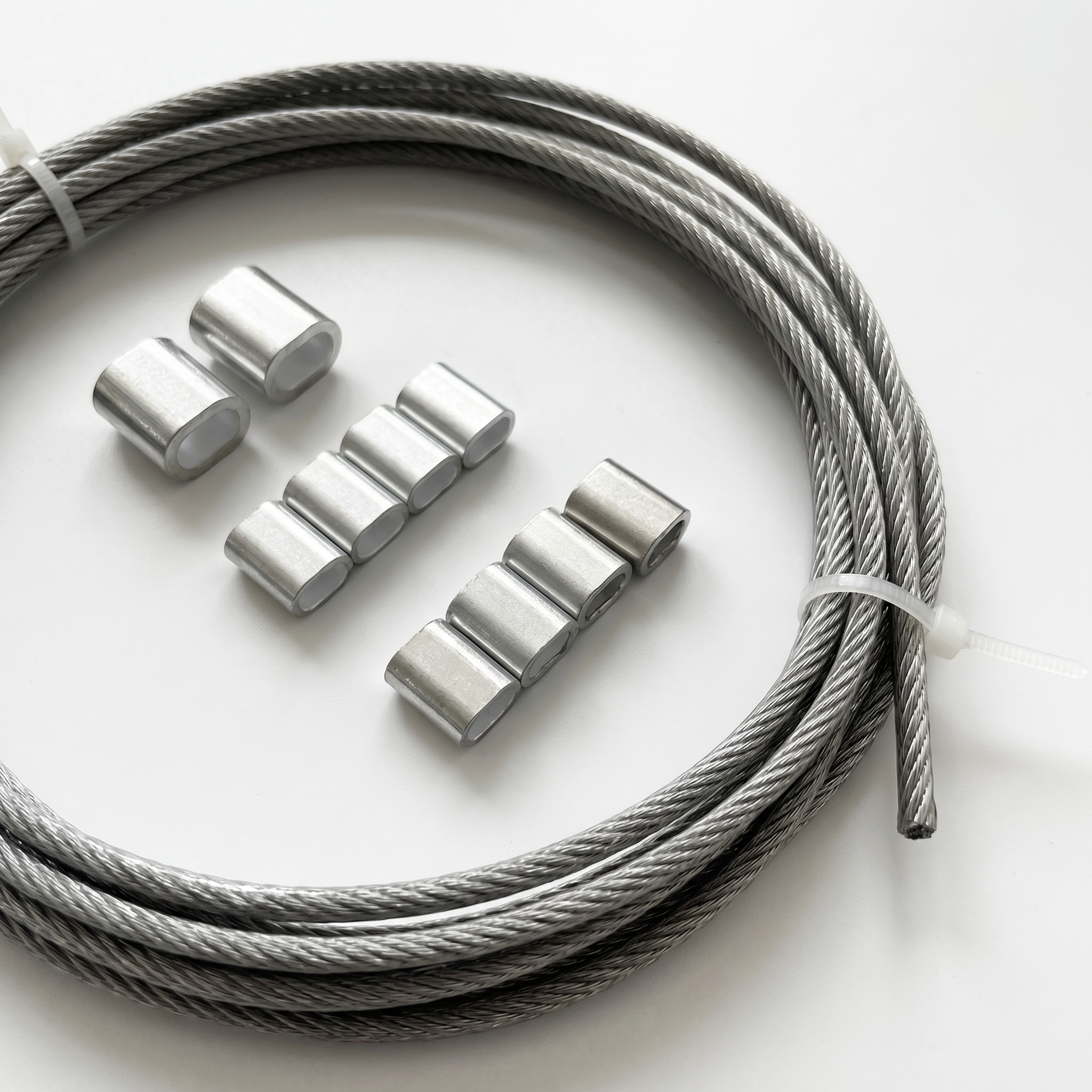 Zoom sur le câble en acier inox de 3 mm et ses manchons en aluminium pour la fixation de filet d'ombrage.