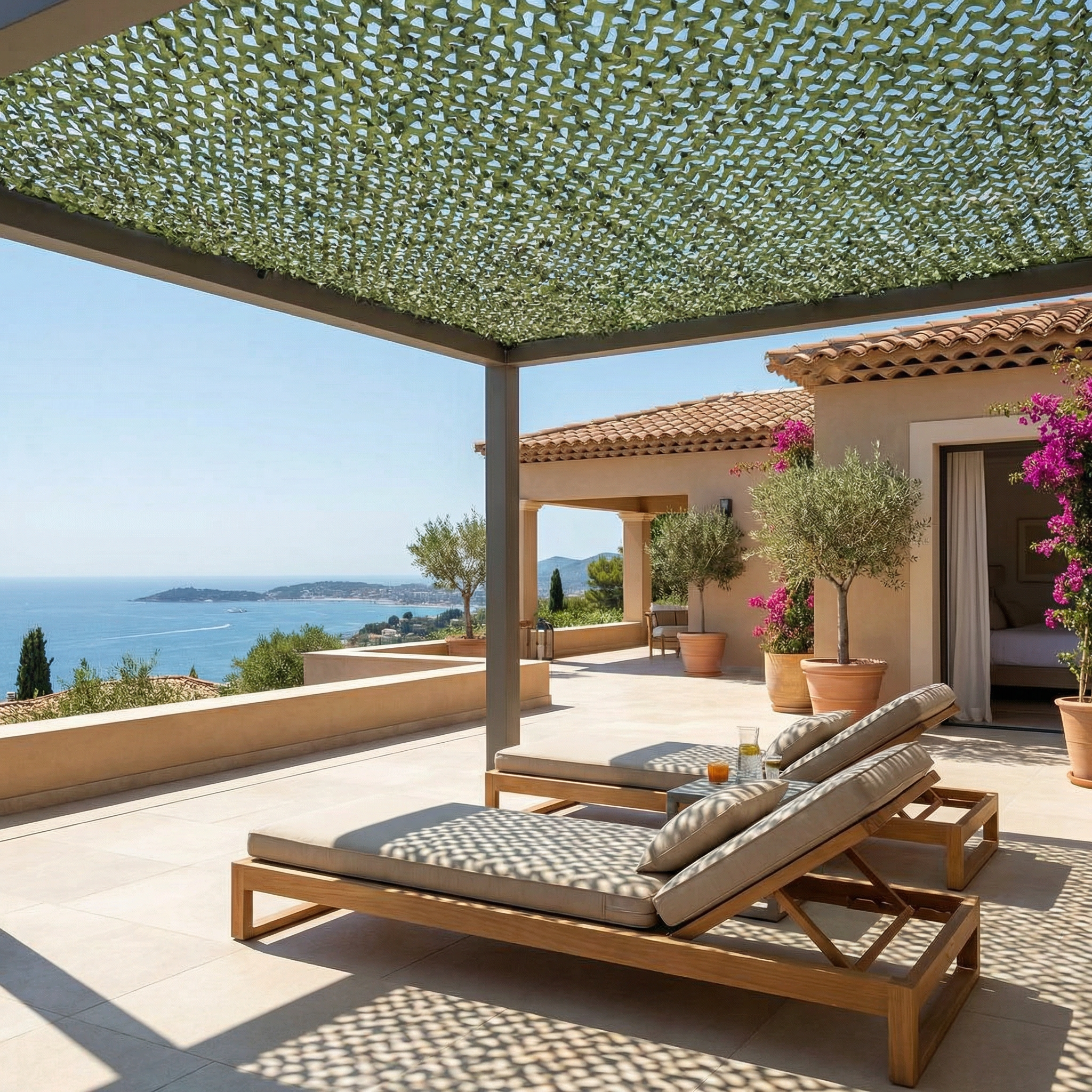 Filet de camouflage renforcé vert Camofil installé sur une pergola de terrasse avec vue sur mer.