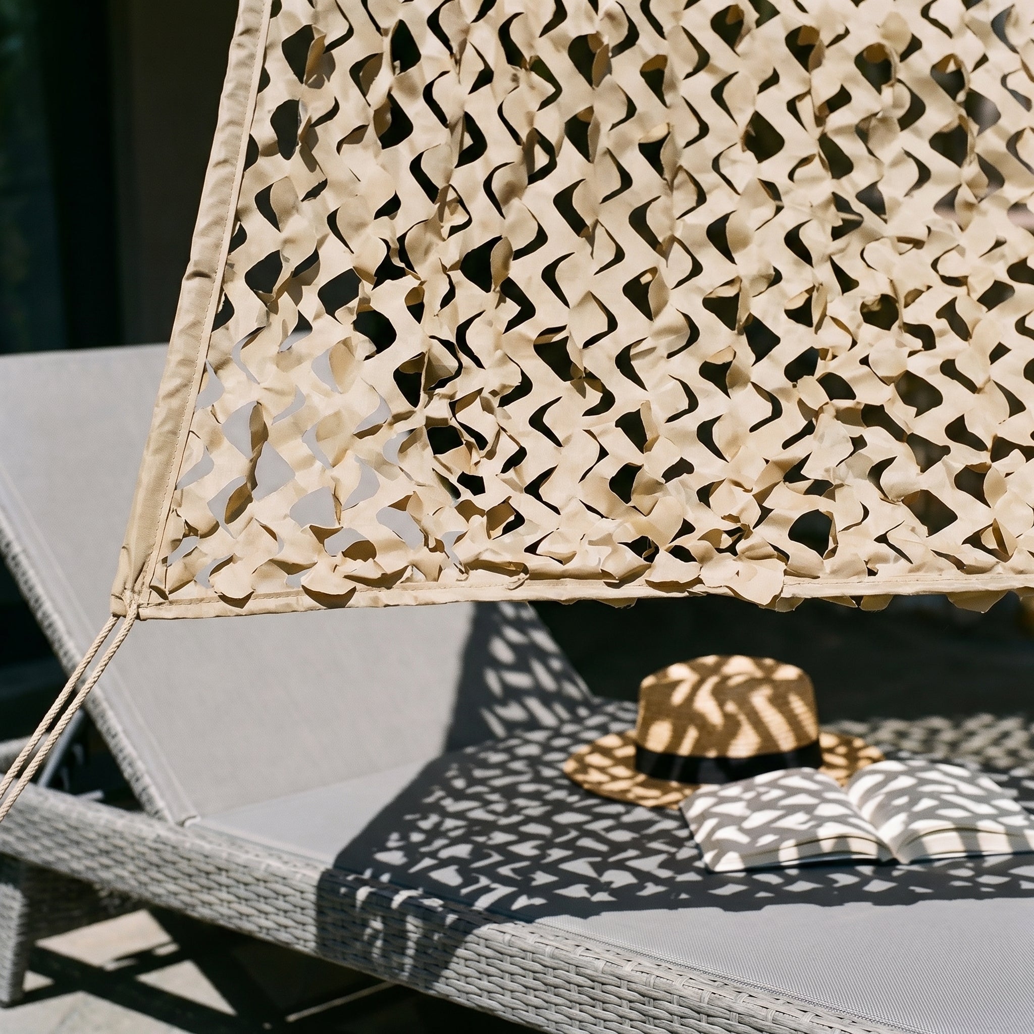 Zoom sur la maille ajourée d'un filet de camouflage triangulaire sable pour terrasse de style bohème.